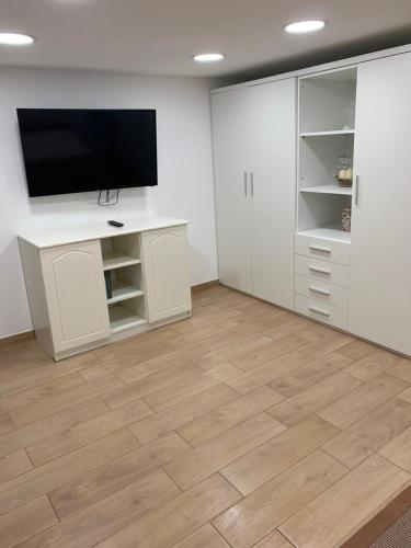 a living room with a tv and a wooden floor at b&b la corte in centro in Caserta