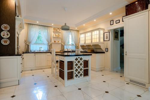 a large kitchen with white cabinets and a kitchen island at Comfortable 4 bedroom villa outdoor wood-fired sauna Warsaw in Magdalenka