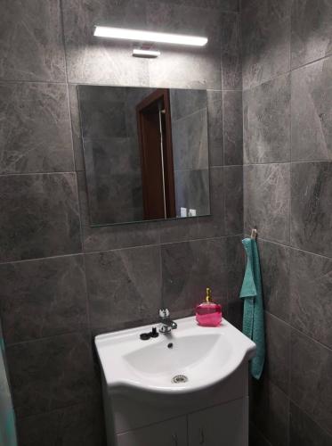 a bathroom with a white sink and a mirror at BeKiVi apartmány in Dunajská Streda