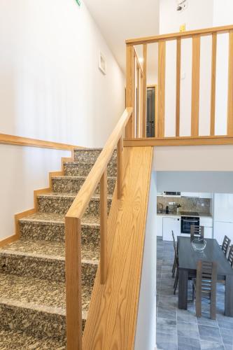 a staircase leading to a dining room and kitchen with a table at Casa do Outeiro in Arcos de Valdevez