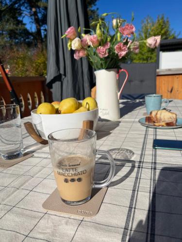 a table with a cup of coffee and a bowl of fruit at Allure in Pirin Golf in Razlog
