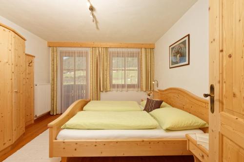 a bedroom with a bed and a window at Innerkohlerhof in Valle Di Casies