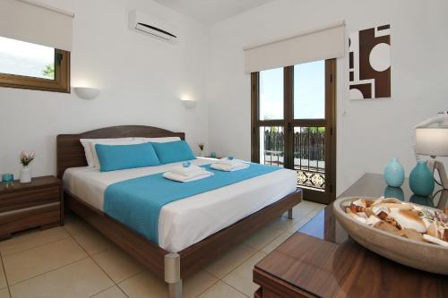 a bedroom with a large bed and a bathroom at Villa Merry in Ayia Napa