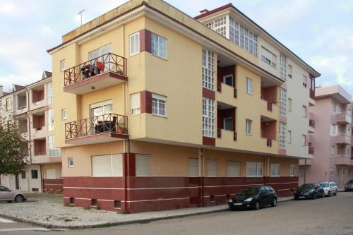 a yellow building with cars parked in front of it at Brisa apart t2 in Ovar