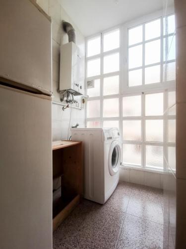 a kitchen with a washing machine and a window at Brisa apart t2 in Ovar