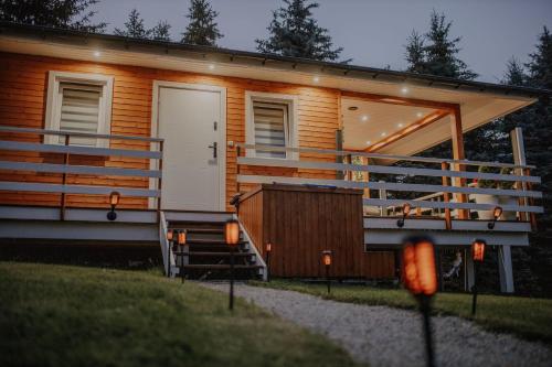 a tiny house with a porch and a white door at Sielanówek - Orzechowa Chatka z sauną wanną termalną jacuzzi in Żywiec
