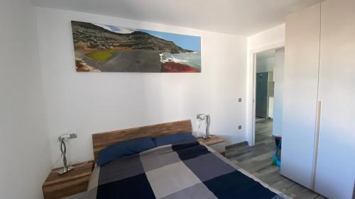 sypialnia z łóżkiem i obrazem na ścianie w obiekcie Casa salzano w mieście Playa Blanca