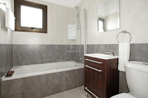 La salle de bains est pourvue d'une baignoire, de toilettes et d'un lavabo. dans l'établissement Villa Merry, à Ayia Napa