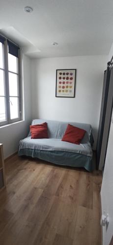 - une chambre avec un lit et 2 oreillers rouges dans l'établissement Dijon centre historique, superbe studio à 2 pas des trams, à Dijon