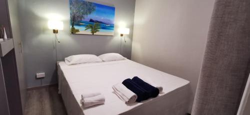 Un dormitorio con una cama blanca con toallas. en Wonderful beach bungalow in the south., en Riambel
