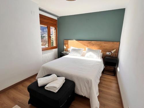 Un dormitorio con una gran cama blanca y una ventana en Fantástico apartamento con vistas en Esterri, en Esterri d'Àneu