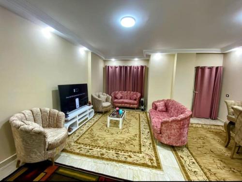 - un salon avec deux chaises et une télévision dans l'établissement Dreams House in Maadi, au Caire