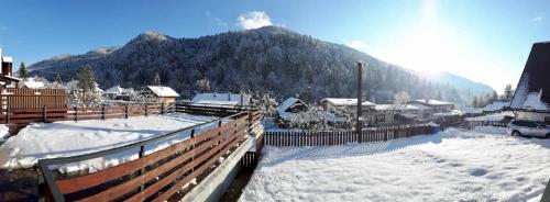 a snow covered village with a mountain in the background at Bystravilla in Bystrá