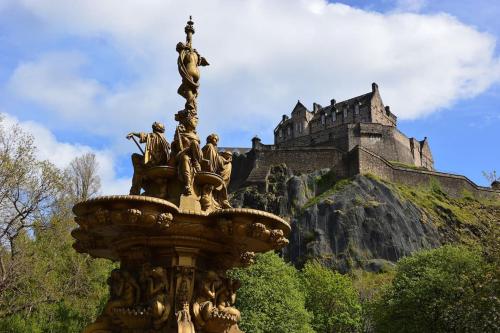 una fuente con un castillo en el fondo en Cosy & Bright Semi-Detached House en Edimburgo