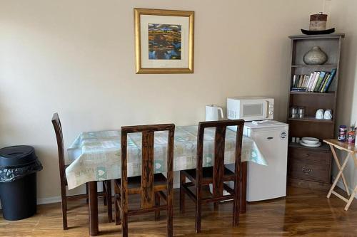 a dining room table with chairs and a microwave at Cosy & Bright Semi-Detached House in Edinburgh