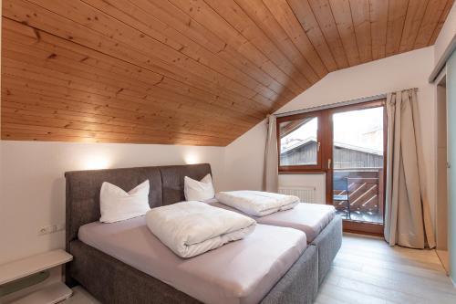 two beds in a bedroom with a wooden ceiling at Haus Saskia in Sölden