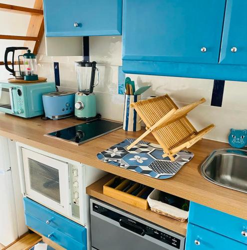 une cuisine avec des placards bleus et un plan de travail avec un évier dans l'établissement Studio Mezzanine La vie en bleu- Vue mer Deauville, à Deauville