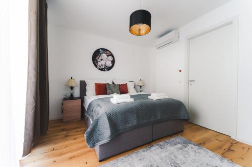 Un dormitorio blanco con una cama grande con almohadas rojas en Triangle City Apartment II, en Viena