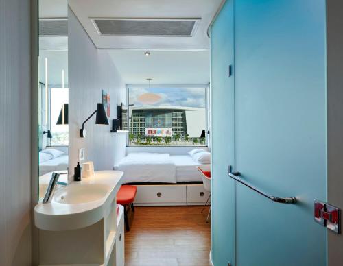 a bathroom with a sink and a bed in a room at citizenM Miami Worldcenter in Miami