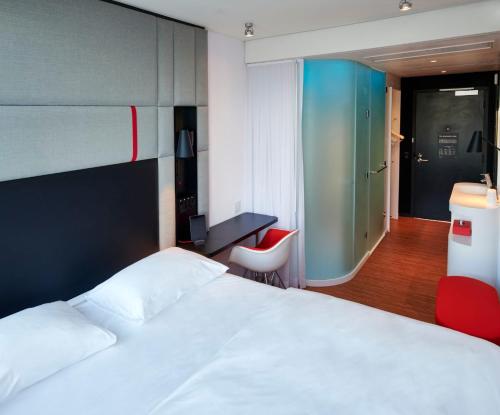 a bedroom with a bed and a desk and a chair at citizenM Miami Worldcenter in Miami
