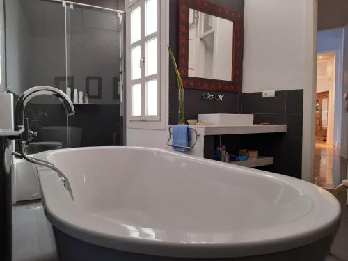 a white bath tub in a bathroom with a mirror at CASA ARCO in Almería