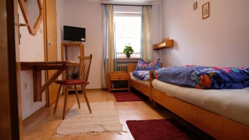 a bedroom with a bed and a desk and a window at Pension Schwarze Berge 