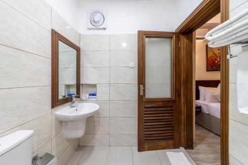 a bathroom with a sink and a mirror at PrideInn Hotel Diani in Diani Beach