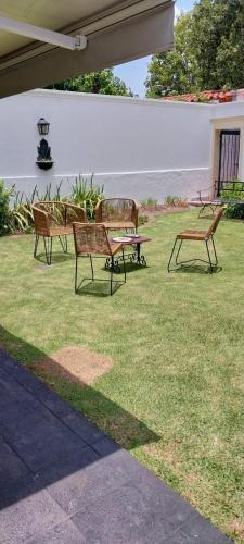 tres bancos sentados en el césped en un patio en Los Aceres en Salta