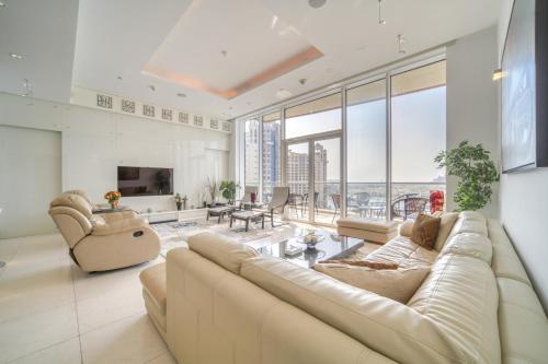 sala de estar con sofá, sillas y ventanas en Tiara Residences, Palm Jumeirah Dubai - Mint Stay en Dubái