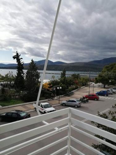 Blick auf einen Parkplatz mit einem weißen Zaun in der Unterkunft Lovely sea front apartment in Itea