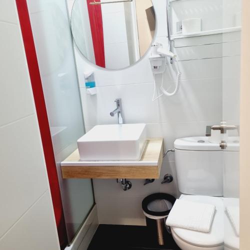 a bathroom with a sink and a mirror at Hostal Lauria in Madrid