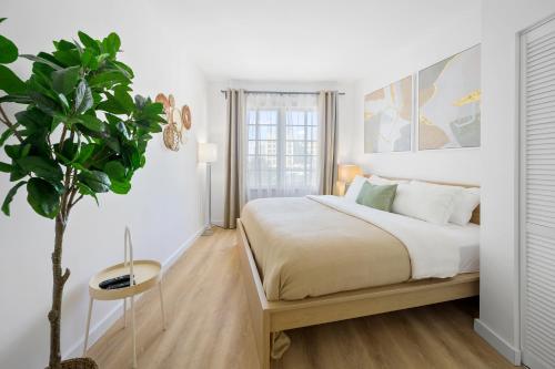 ein Schlafzimmer mit einem Bett und einer Topfpflanze in der Unterkunft Barbizon on Ocean Drive Apartments in Miami Beach