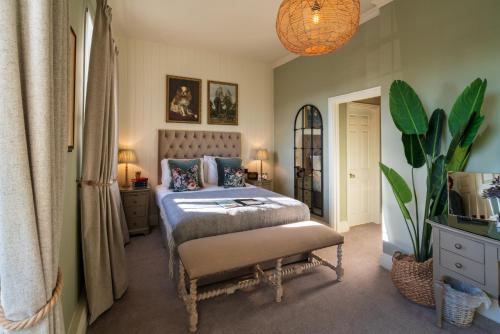 - une chambre avec un lit et une plante en pot dans l'établissement Prince of Burford, à Burford