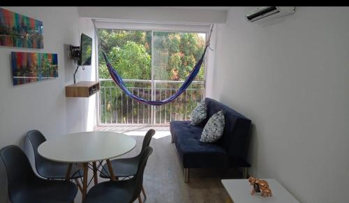 a living room with a table and chairs and a window at Apartamentos Dreams TR in Santa Marta