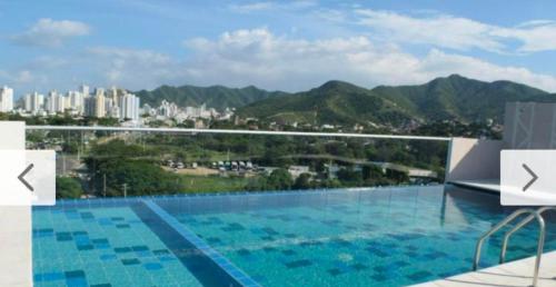 a large swimming pool with a view of a city at Apartamentos Dreams TR in Santa Marta