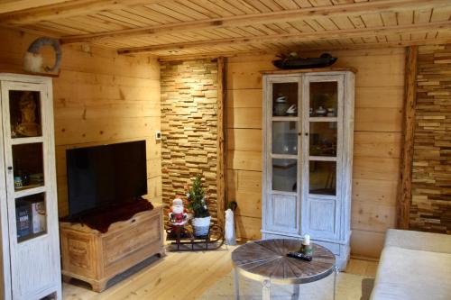 a living room with a tv and a wooden wall at Alpenchalet Piz Hüsli in Tschagguns