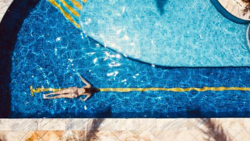 a person swimming in a swimming pool at ThalassaGarden Hotel - Pousada in Pipa
