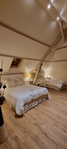ein Schlafzimmer mit einem großen weißen Bett im Dachgeschoss in der Unterkunft Un Parfum de Campagne in Méaulte