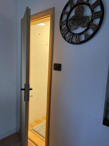 a clock on a wall next to a door at Vila Xenos Loft Karakter Zlatibor in Zlatibor