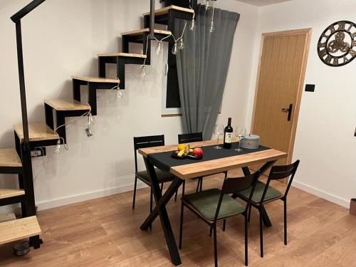a dining room with a table and chairs and a staircase at Vila Xenos Loft Karakter Zlatibor in Zlatibor