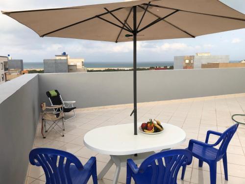 a table and chairs with an umbrella on a roof at Luxurious house in Morocco overlooking the Mediterranean Sea 