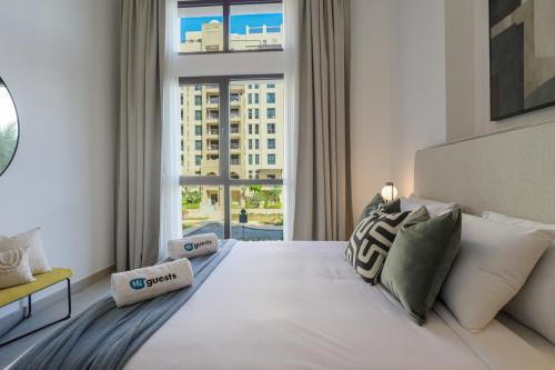 a bedroom with a large white bed with a large window at HiGuests - Charming Modern Apartment Close To The Souk in MJL in Dubai