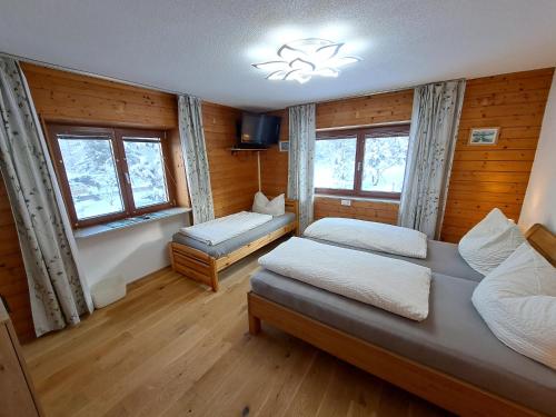 a bedroom with two beds and two windows at Apartmenthaus PARADISE in Innsbruck