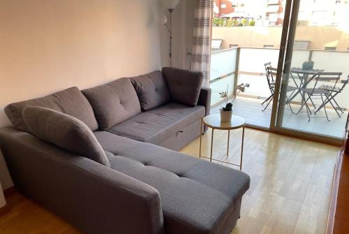 ein Wohnzimmer mit einem grauen Sofa und einem Tisch in der Unterkunft NEW! Amazing 2 bedroom apartment in Rambla del Poblenou in Barcelona