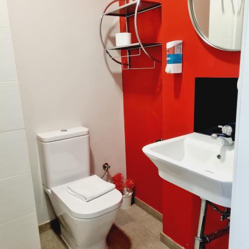 a bathroom with a white toilet and a sink at Hostal Lauria in Madrid