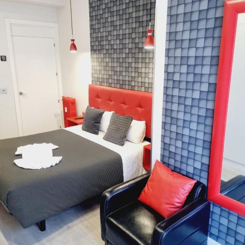 a bedroom with a bed and a chair at Hostal Lauria in Madrid