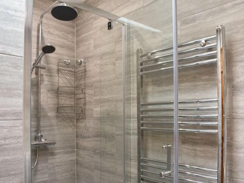 a shower with a glass door and a shower head at The Nook in Thirsk