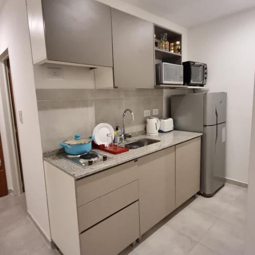 a small kitchen with a sink and a refrigerator at AZ Suites Resistencia in Resistencia