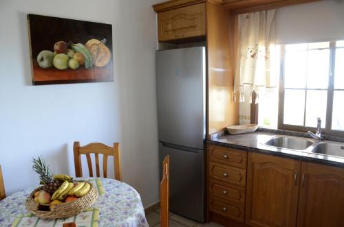 蒂哈拉費的住宿－Villa Estrella，厨房配有冰箱和带一碗水果的桌子
