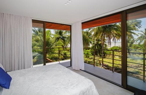 a bedroom with a bed and a large window at Casa Maçunim 1 in Pôrto de Pedras